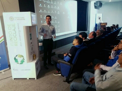 Roger Martínez mostrando el funcionamiento de la máquina recicladora 