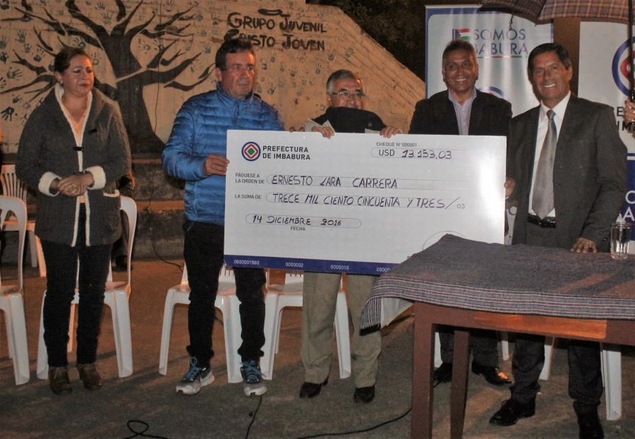 Entrega simbólica del cheque por el 50 por ciento del valor de la obra en el barrio Tanguarín. Están presentes los dirigentes y el prefecto de Imbabura, Pablo Jurado. 