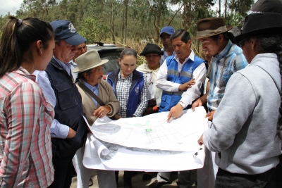 En Gualopuro, las autoridades y los dirigentes comunitarios revisan los planos en donde constan los tramos viales que requieren intervención urgente. 