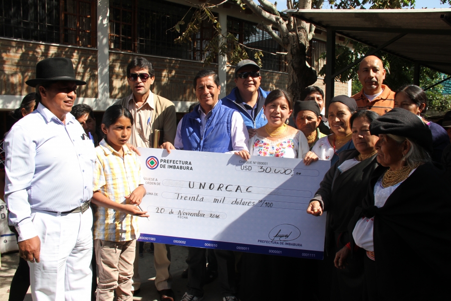 El prefecto Pablo Jurado entrega simbólicamente el cheque de 30.000 dólares para la construcción de un espacio de comercio de productos en la UNORCAC. 