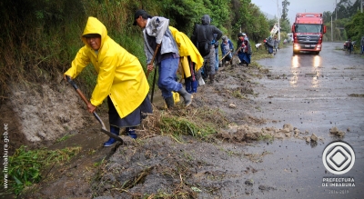 En medio de una pertinaz lluvia, moradores de la comunidad Corazón de Perugachi participando en la minga de limpieza de la carretera.