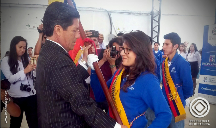 El prefecto de Imbabura, Pablo Jurado, entrega el Pabellón Nacional a la Abanderada del Plantel, Fernanda Mediavilla. 