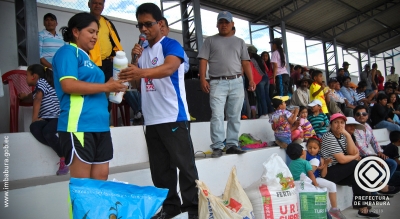 Edwin González, subdirector de Fomento Productivo de la Prefectura, entrega los insumos orgánicos y químicos a la presidenta del Gobierno Parroquial de Tumbabiro, Jenny Rivera, para que sean utilizados en la siembra de césped.