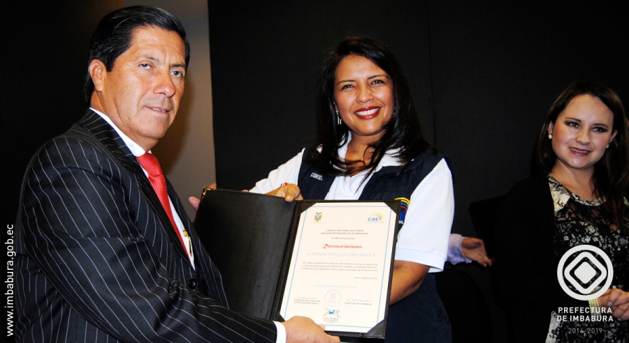 Ximena Silva, Consejera del CNE, entrega al Prefecto de Imbabura, Pablo Jurado, el reconocimiento de la institución por el apoyo al fortalecimiento de la democracia.